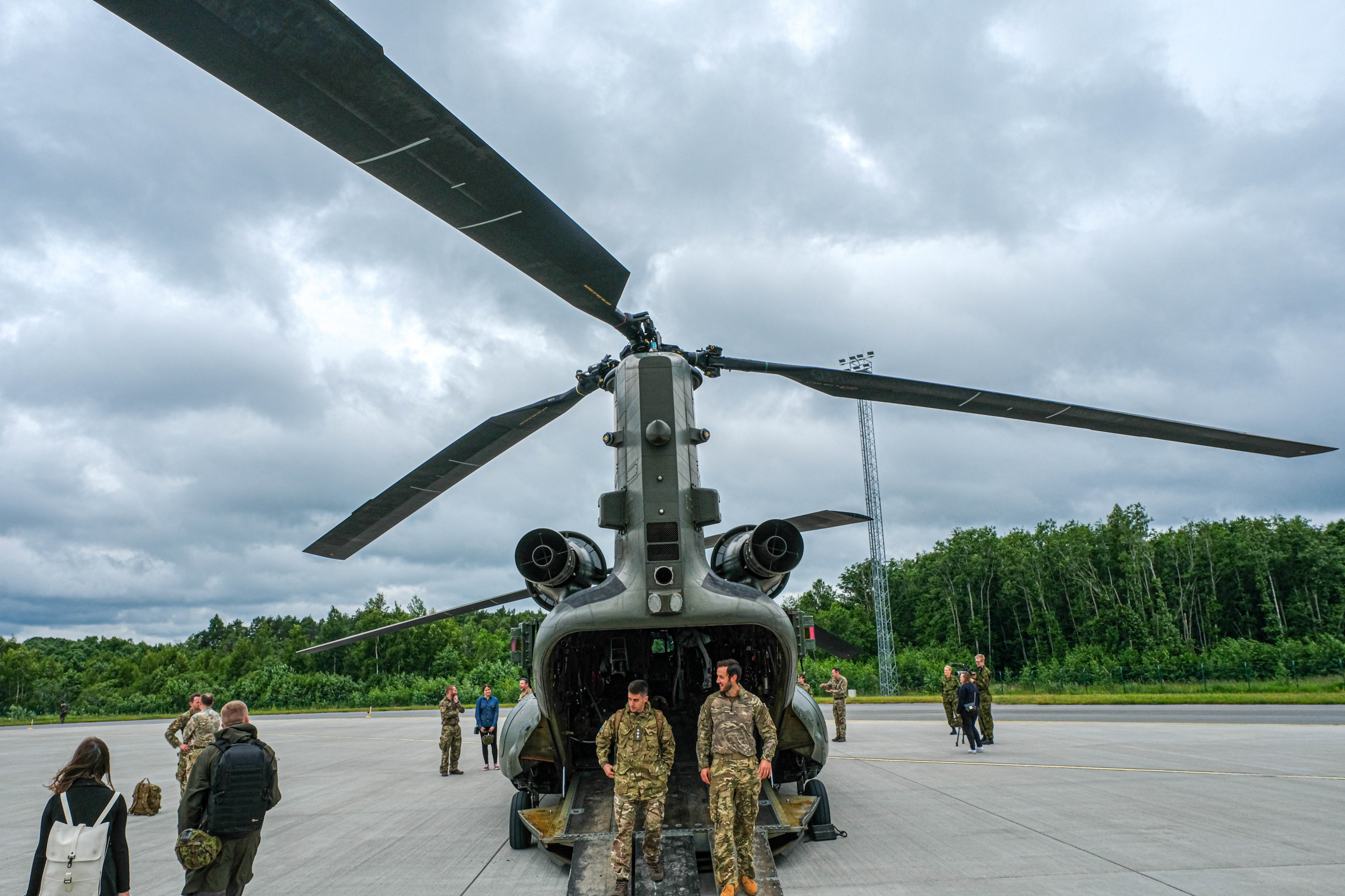Image shows RAF Regiment aviators standing by the open loading bay of a RAF Chinook on the airfield.